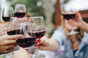 Hands holding red wine glasses